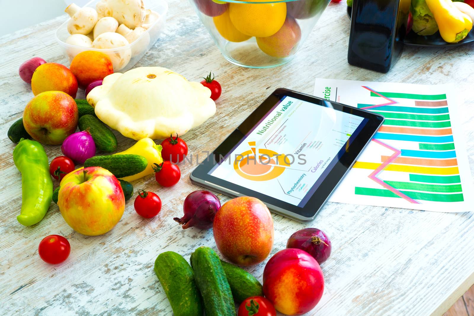 Organic food and a Tablet PC showing information about healthy nutrition and phytochemical composition.