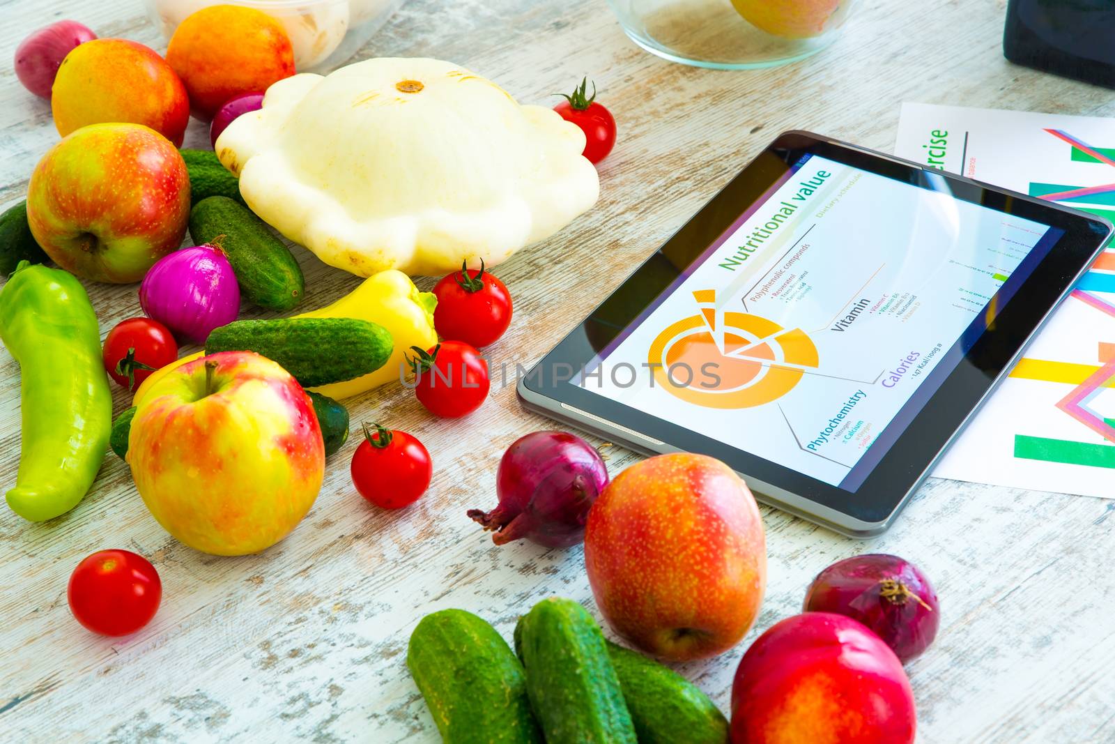 Organic food and a Tablet PC showing information about healthy nutrition and phytochemical composition.