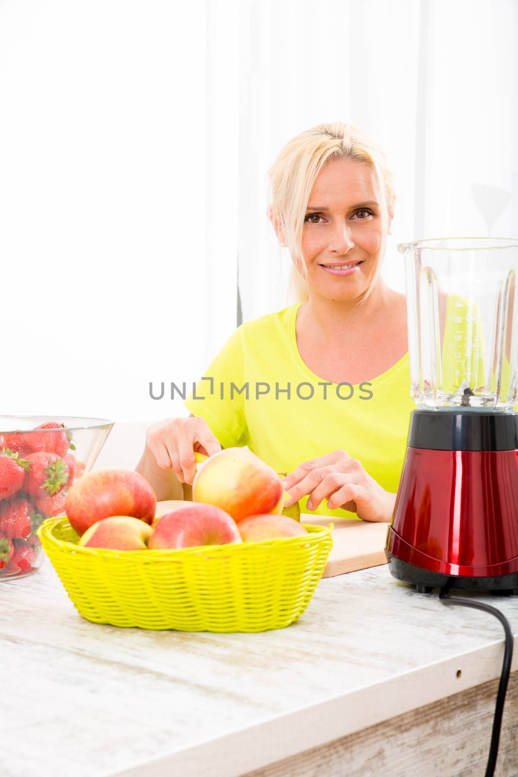 Mature woman preparing a smoothie by Spectral