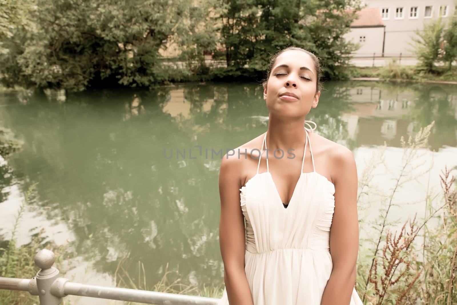 A young girl standing on a bridge.