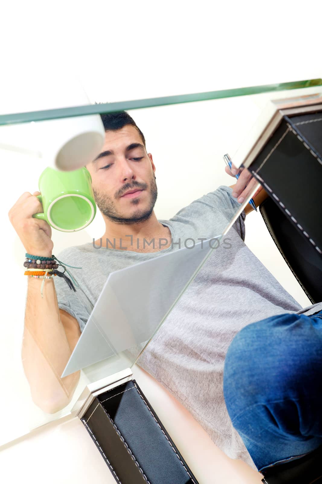 Portrait of a young man in grey shirt in the office.
