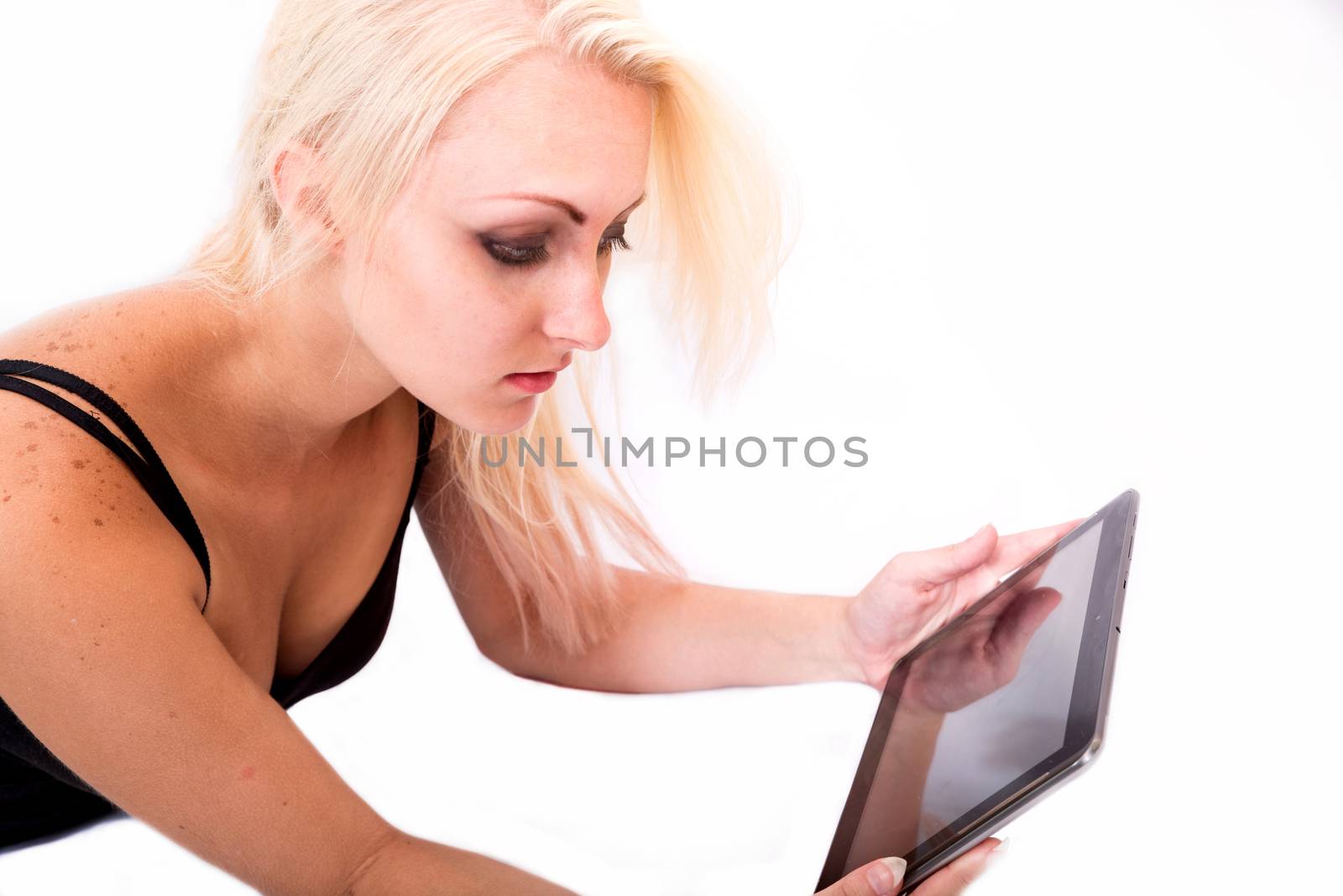 Portrait of a blonde alternative girl lying on the ground holding a tablet PC.