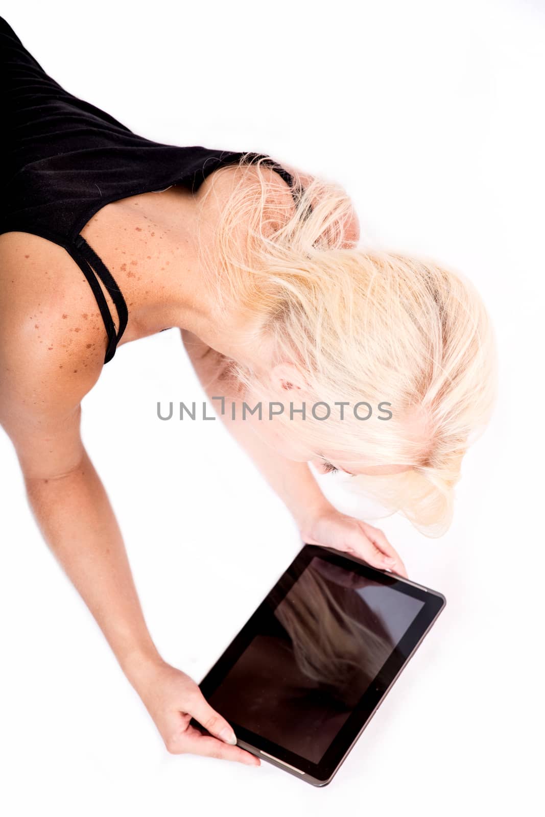 Portrait of a blonde alternative girl lying on the ground holding a tablet PC.