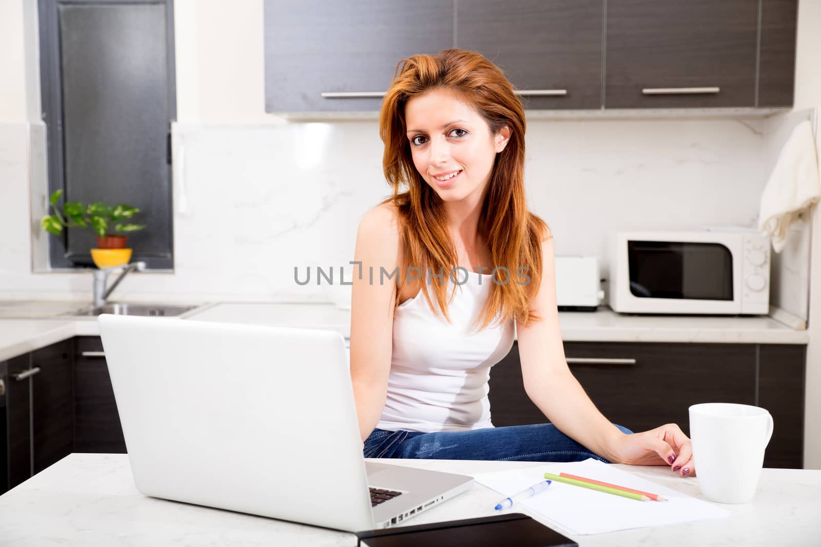 Portrait of a brunette girl working in the kitchen.