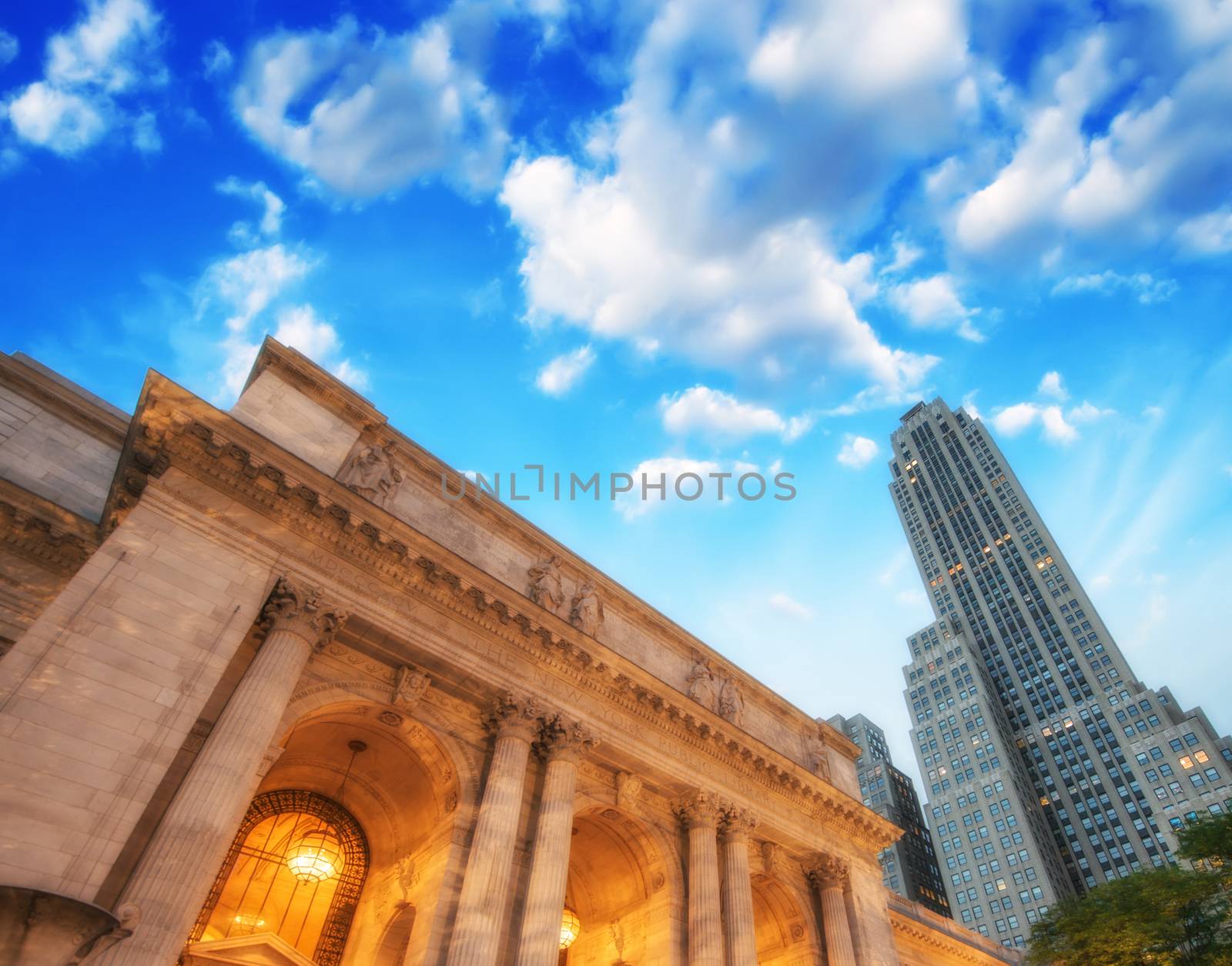 The New York Public Library. Side view with surrounding buildings and dramatic sky.