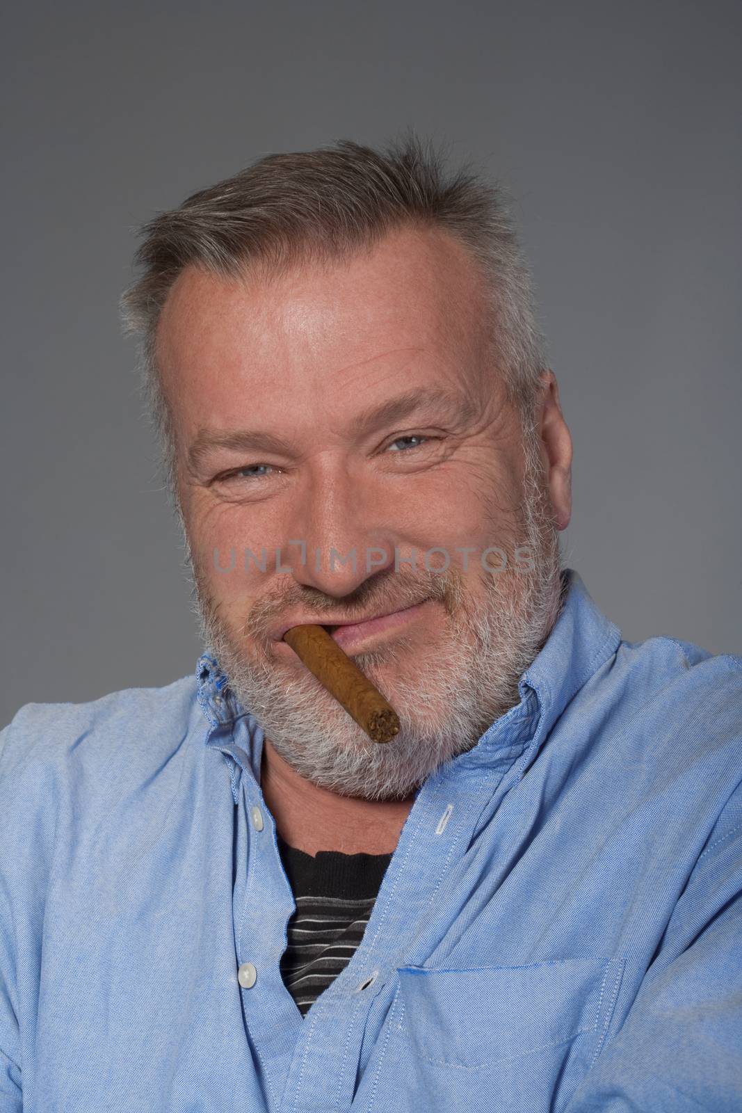 studio portrait of a middle aged man in shirt with a cigar