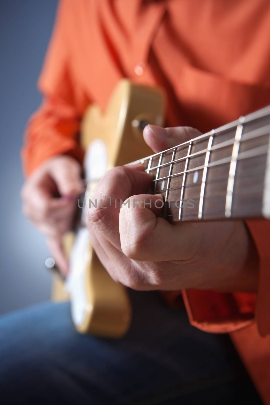 closeup of hands of a musician playing electric guitar