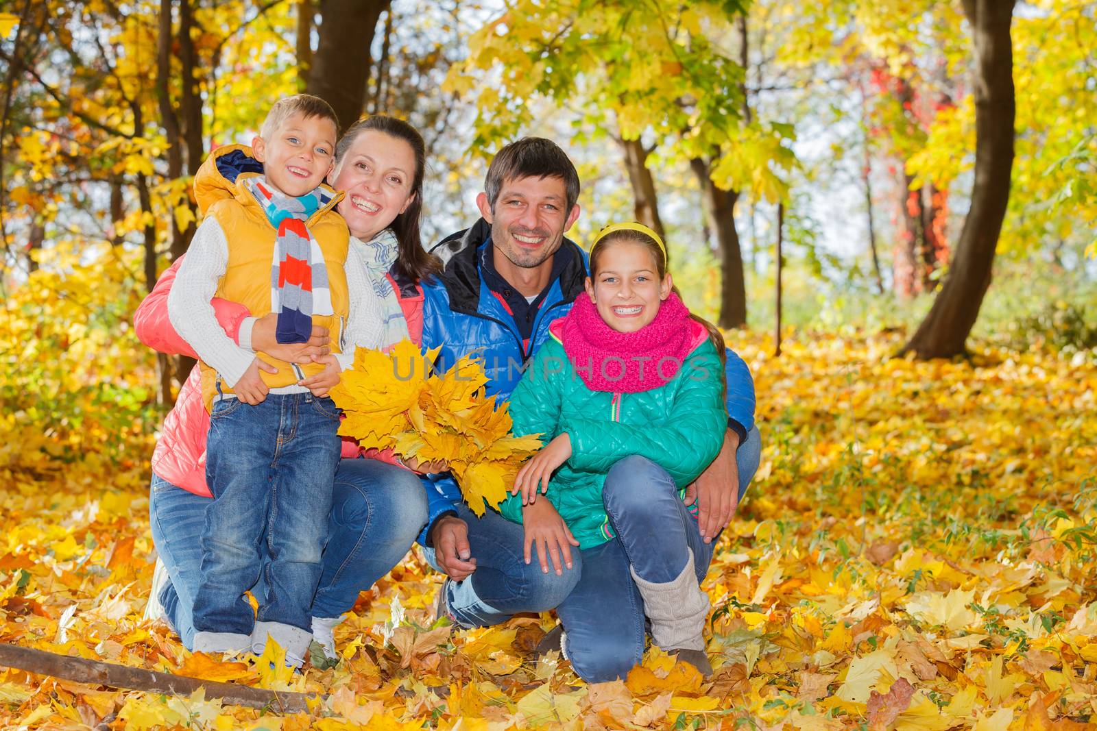 Portrait of happy family relaxing in autumn park