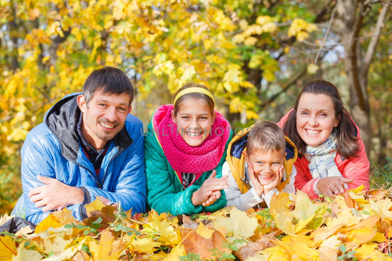 Family relaxing in park by maxoliki