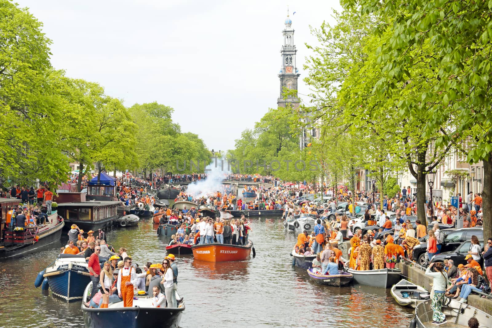 AMSTERDAM - APRIL 26: Amsterdam canals full of boats and people in orange at the Prinsengracht during the celebration of kings day on April 26, 2014 in Amsterdam, The Netherlands