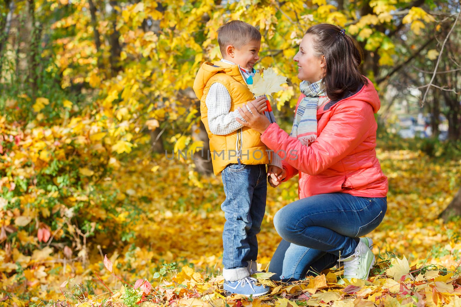 Portrait of mother with her son relaxing in autumn park