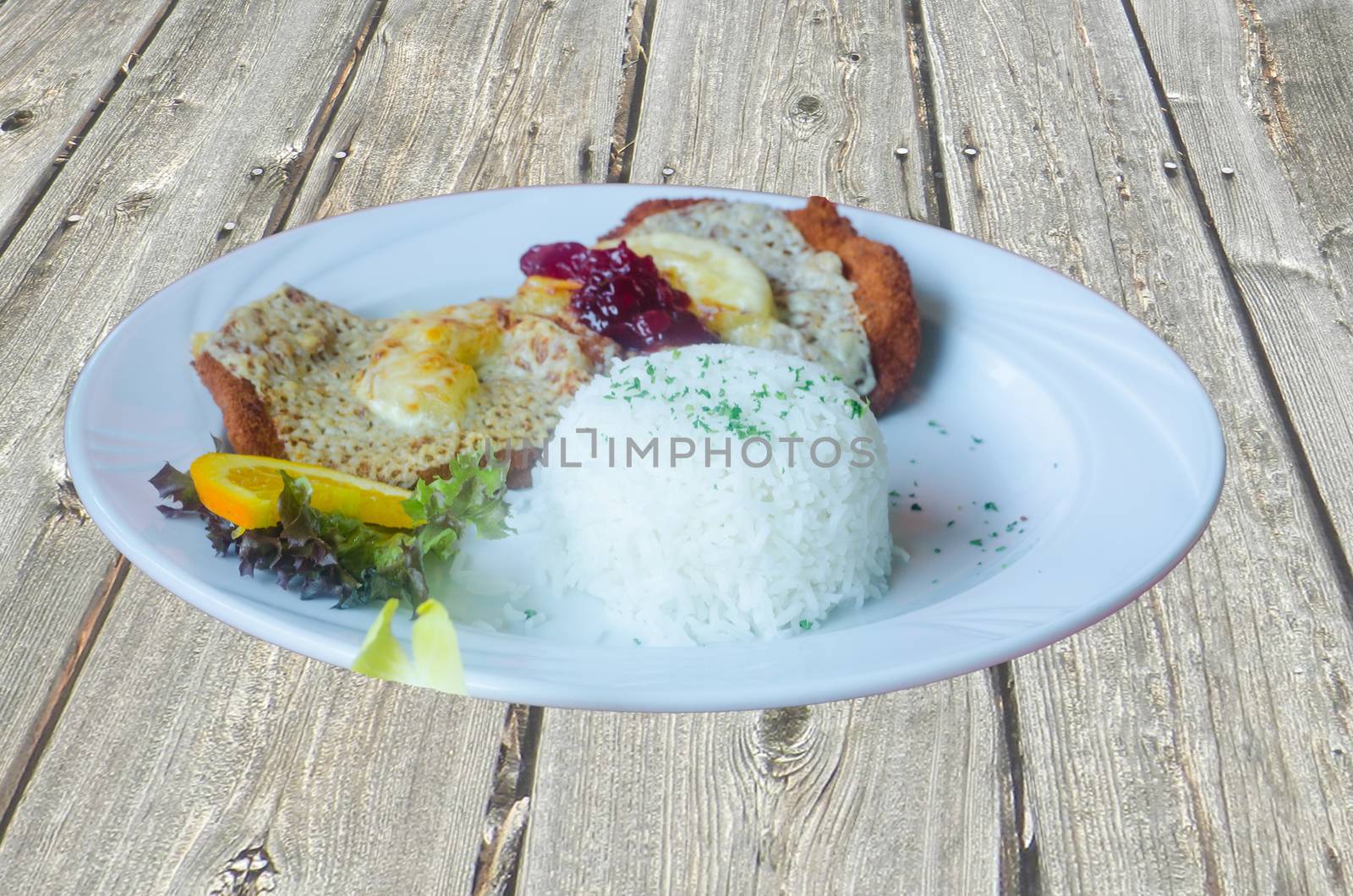 Cutlet unbreaded with pineapple slices with salad and rice also called Hawaii escalope.
