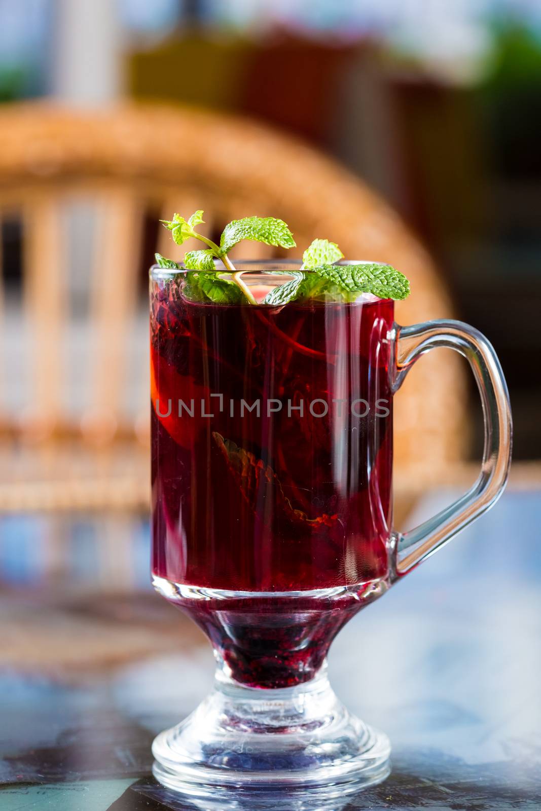 Blackberry tea in a glass cup. Decorated with mint leaves