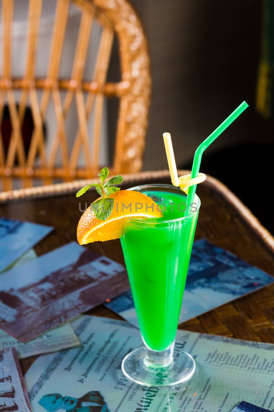Alcoholic cocktail decorated with orange and mint leaves