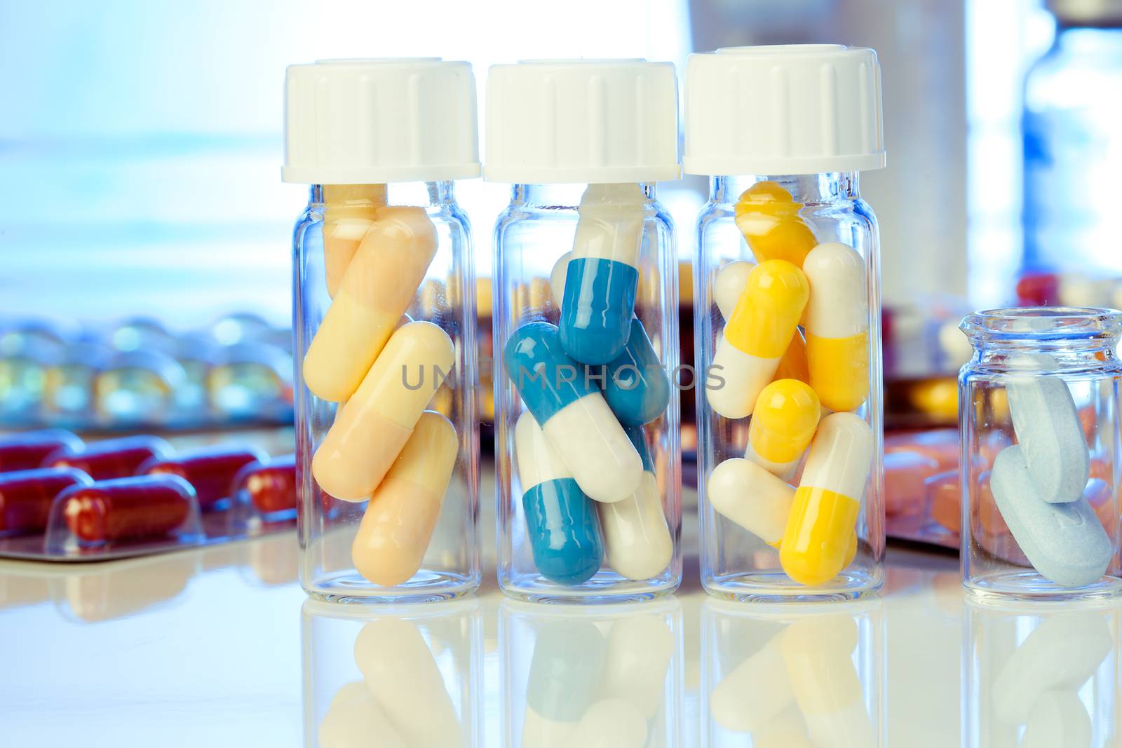Colorful medical capsules in bottle, on white background.