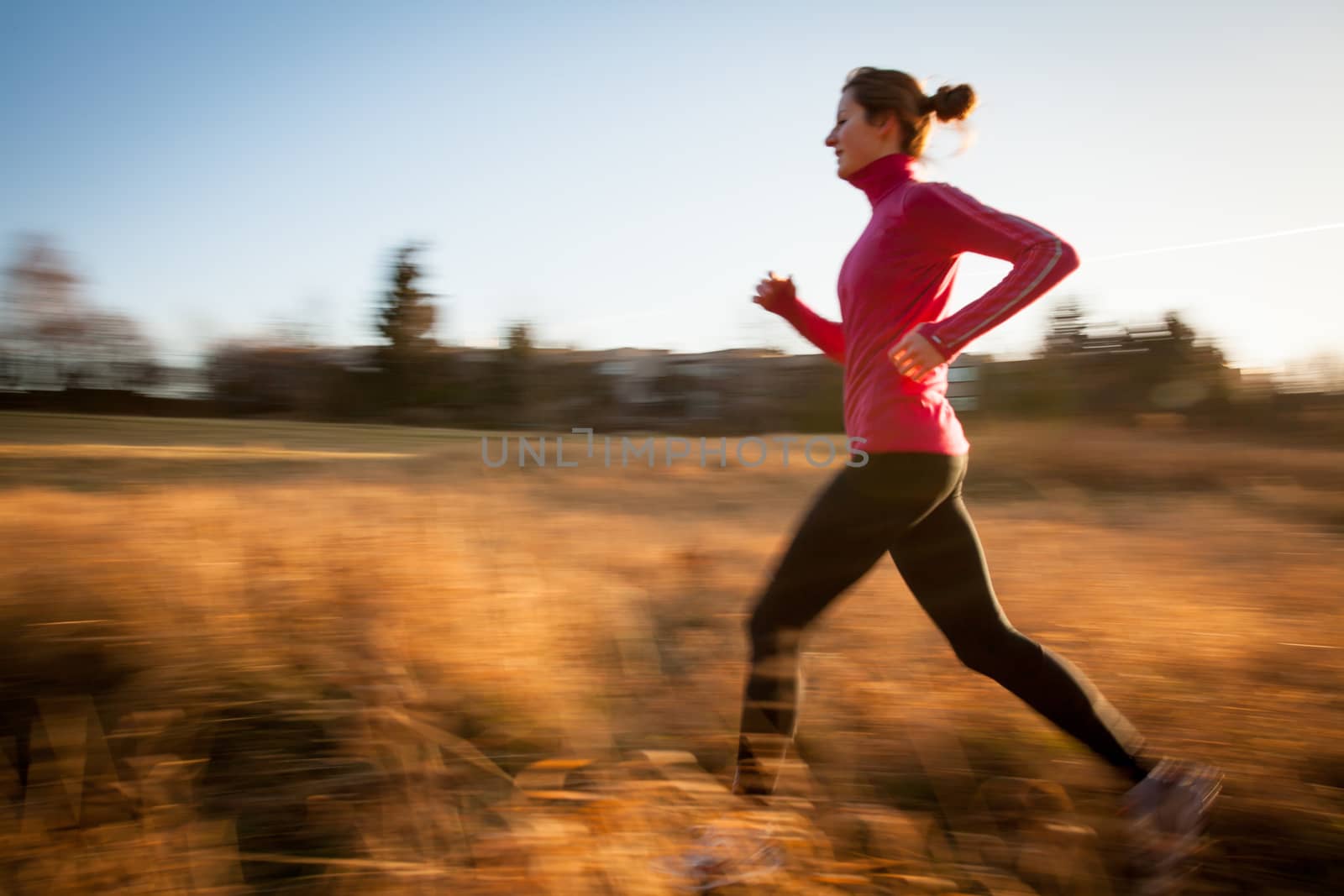 Young woman running outdoors by viktor_cap