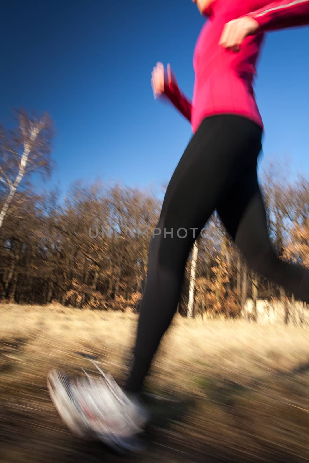 Young woman running outdoors on a lovely sunny winter/fall day by viktor_cap