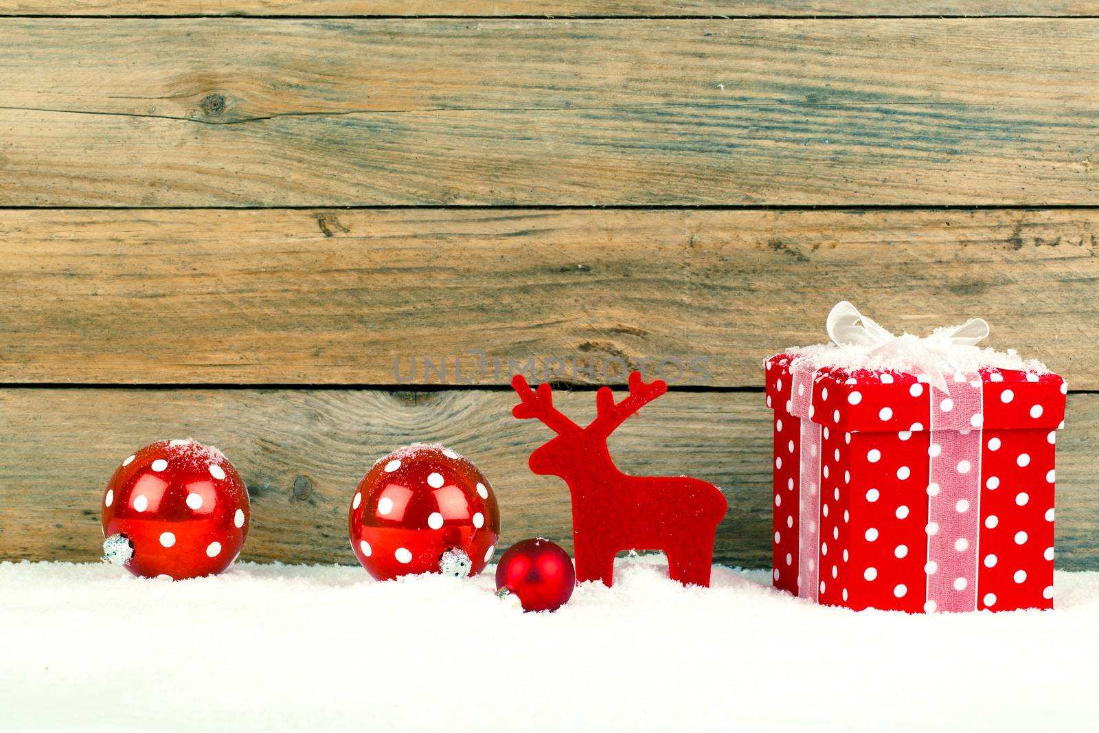 red gift for christmas on a wooden background with snow