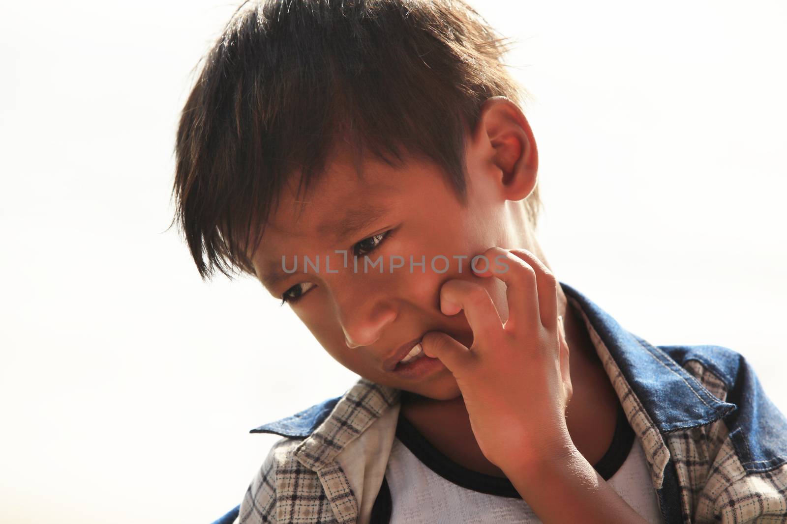 BALI, INDONESIA - 21 DECEMBER, 2009: casual portrait of an unknown pensive Indonesian child in Bali, 21 December 2009, Indonesia 