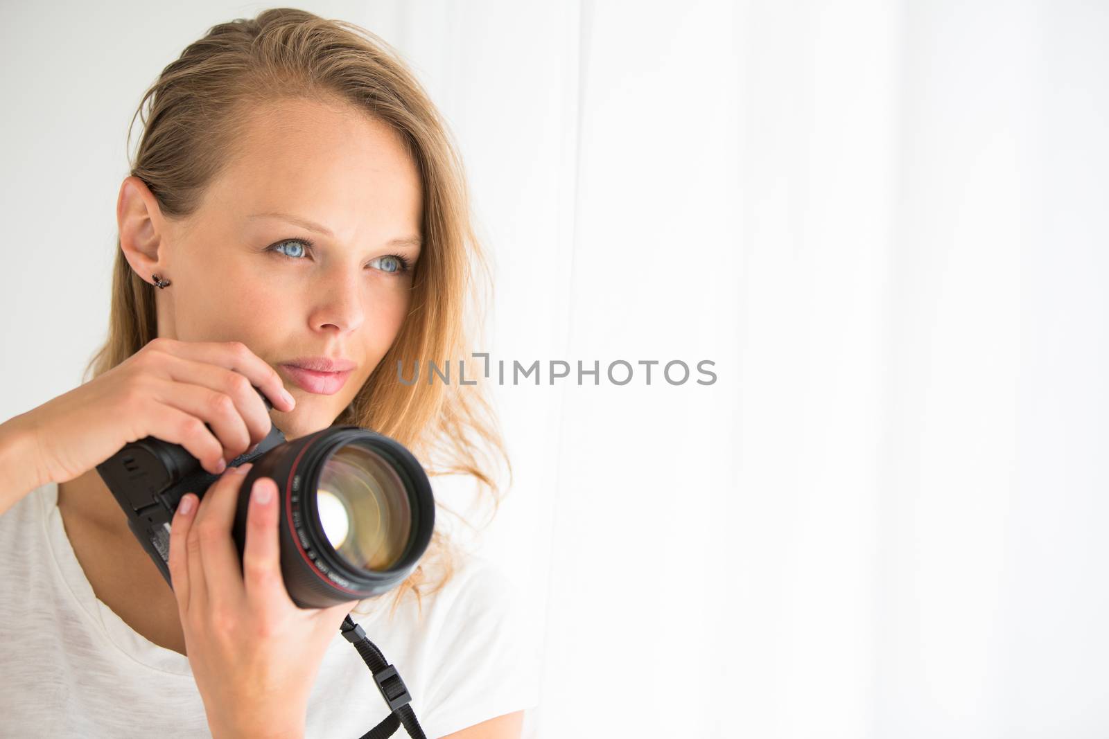 Pretty, female photographer with digital camera - DSLR and a huge telephoto lens (color toned image; shallow DOF)