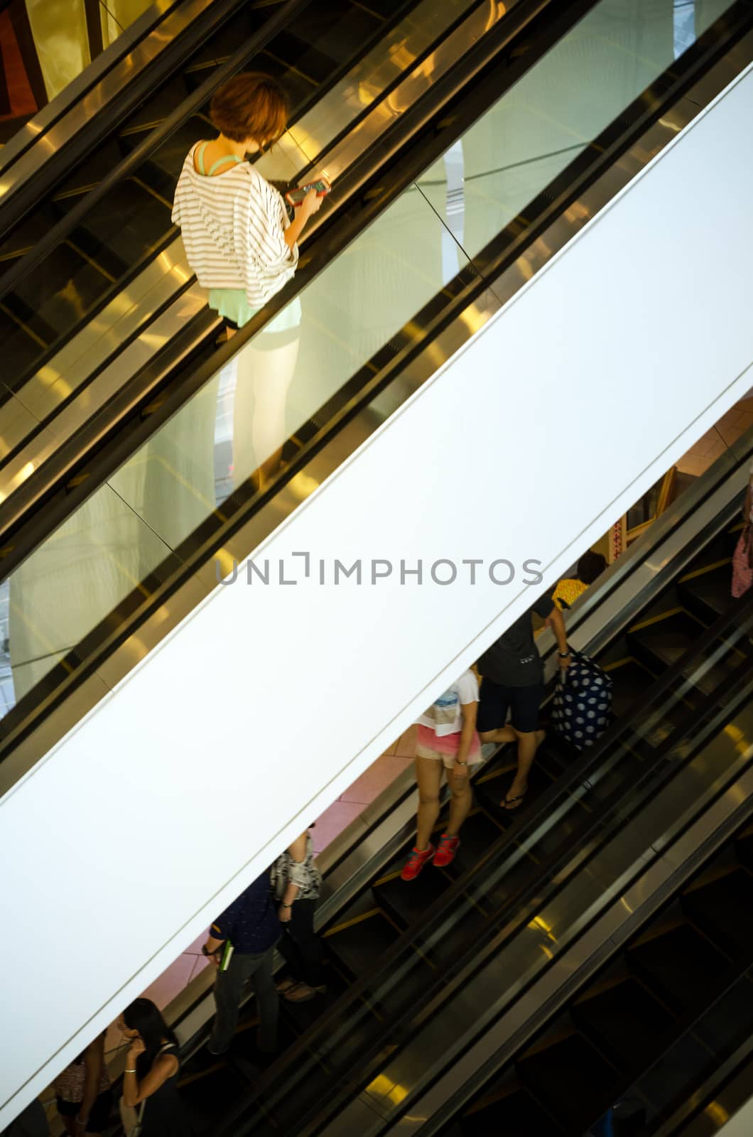 Bangkok, Thailand - September 12, 2013: Shoppers on escalator at Terminal21 shopping mall on September 12, 2013. Terminal21 is a new shopping mall in the Asok district in Bangkok, Thailand