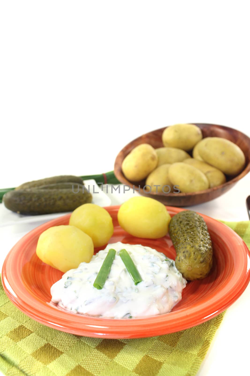 Potatoes with curd, pickles and chives on a light background