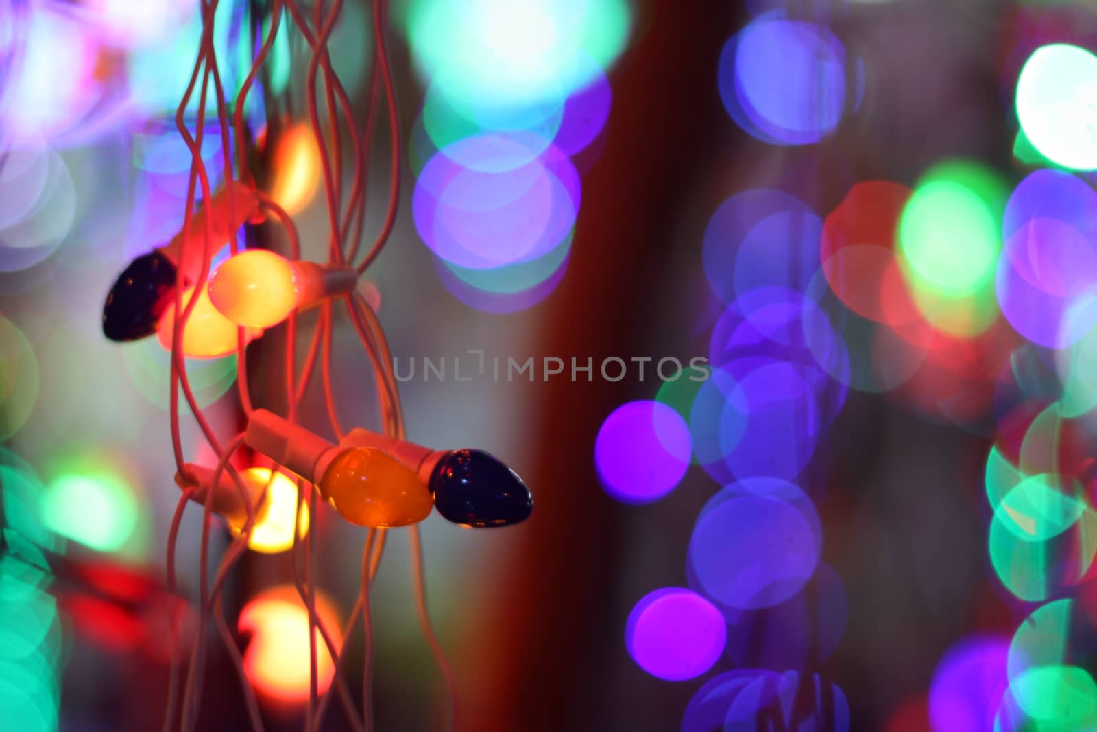 A string of colorful bulbs with a backdrop of colorful lights.