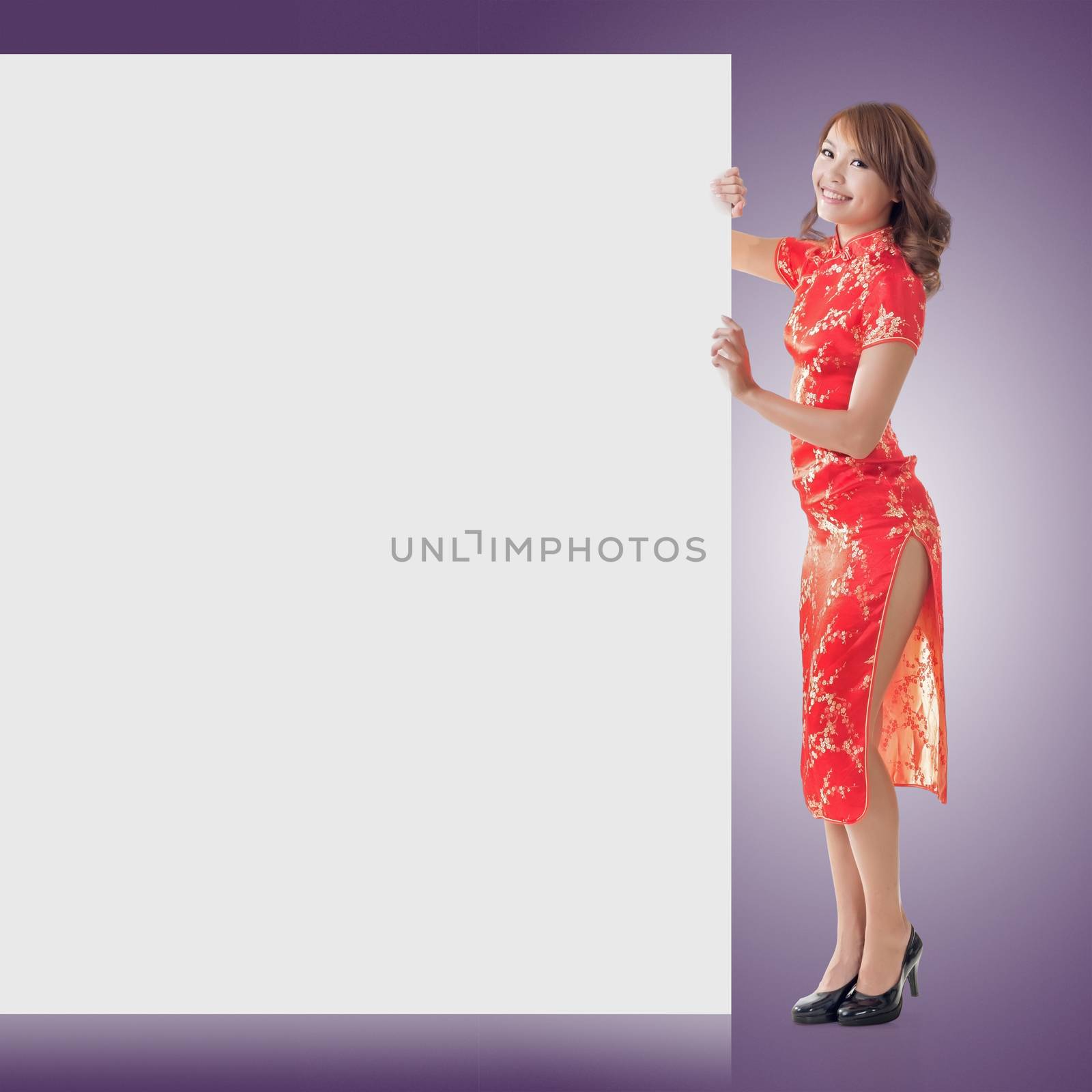 Attractive Chinese woman dress traditional cheongsam and hold blank board, full length portrait.