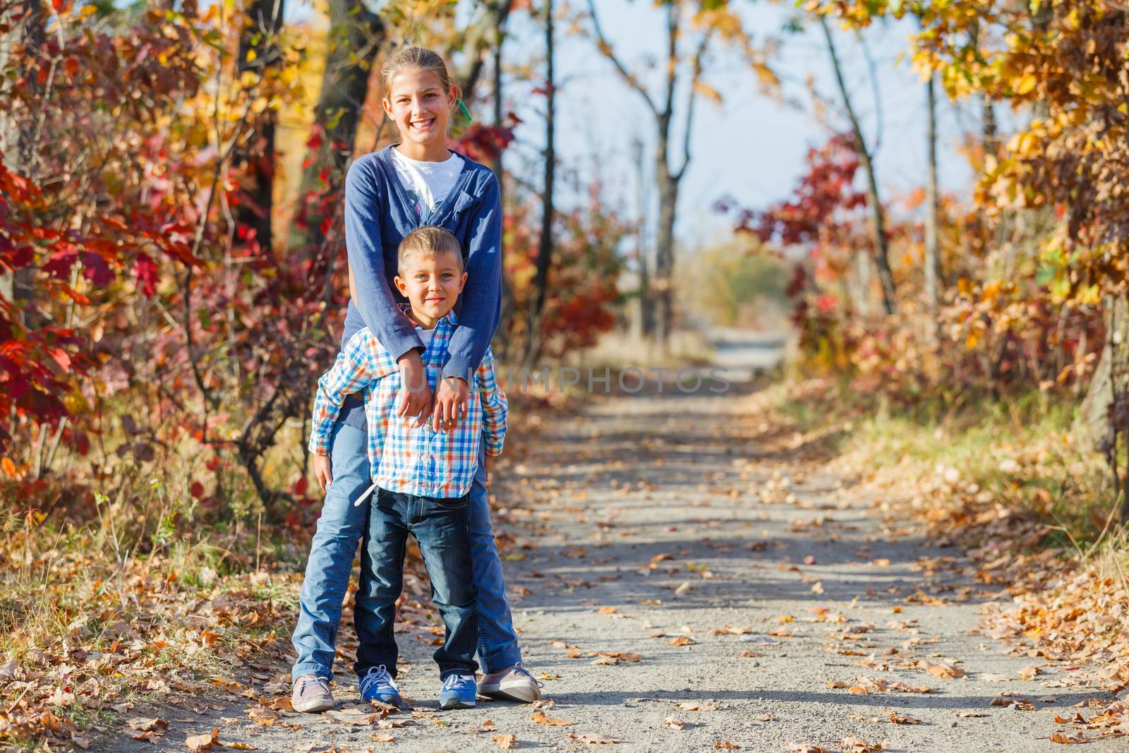 Adorable cute boy and girl has fun in the beautiful autumn park