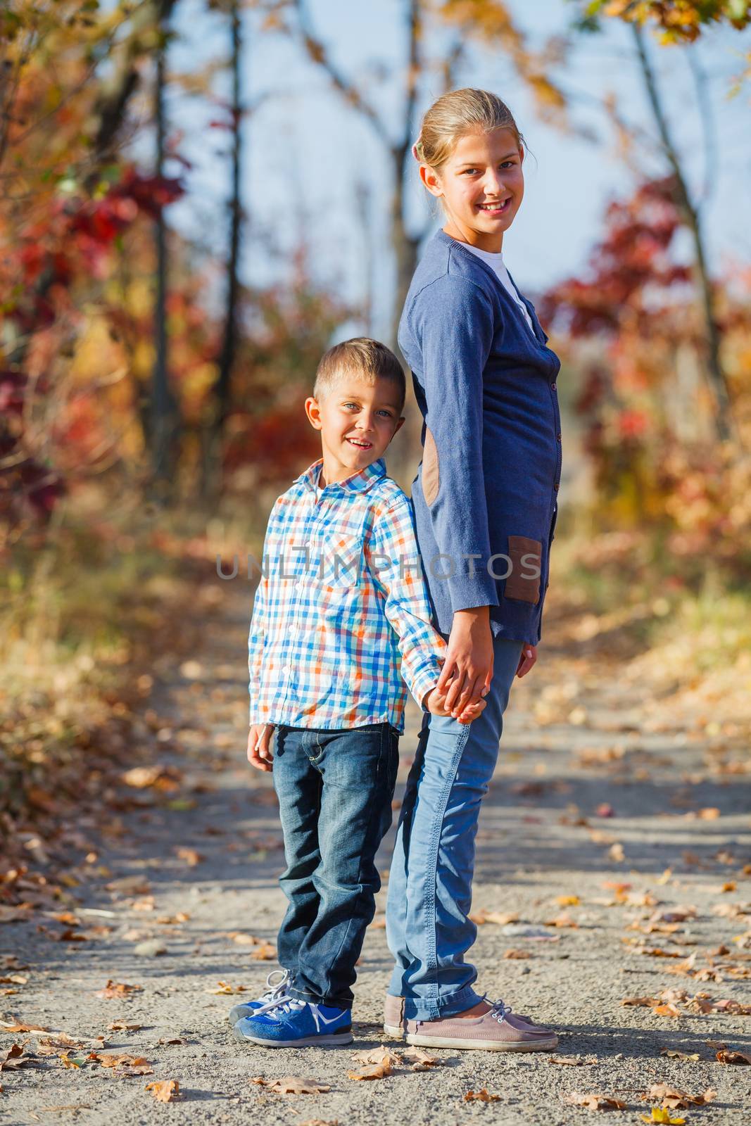 Adorable cute boy and girl has fun in the beautiful autumn park