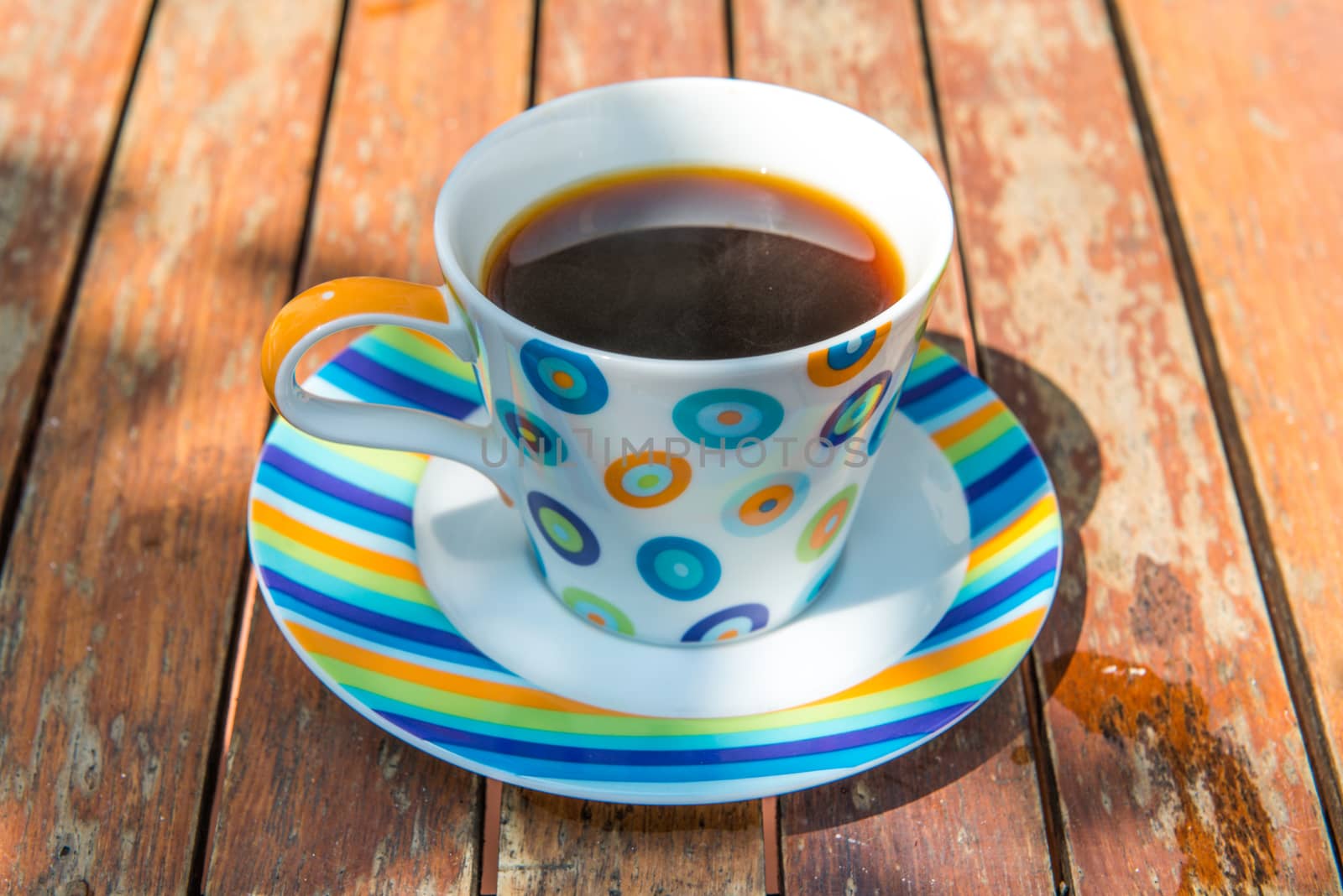 Colorful cup of coffee on wooden table 