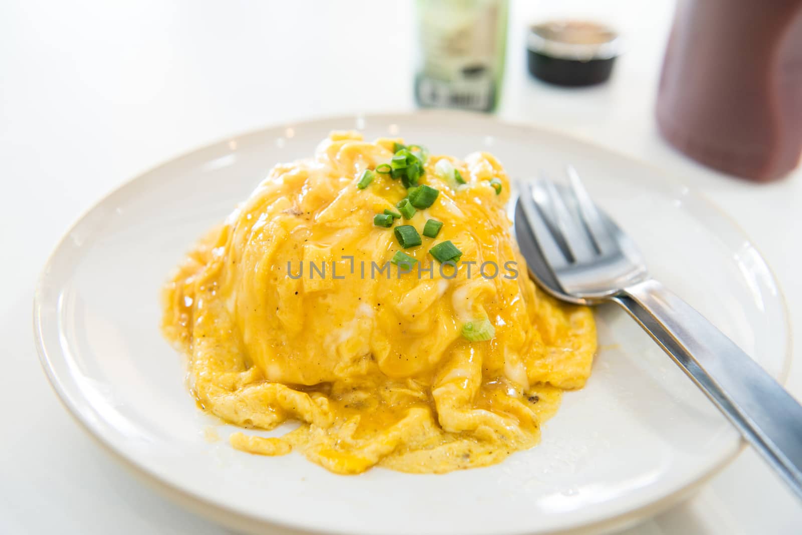 creamy omelet on rice in white plate