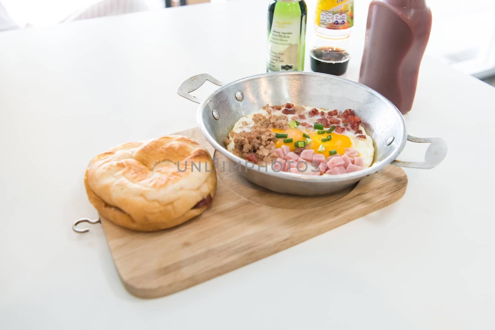  Healthy breakfast - fried eggs, ham, bacon, pork in the pan and bread on wooden plate. Selective focus