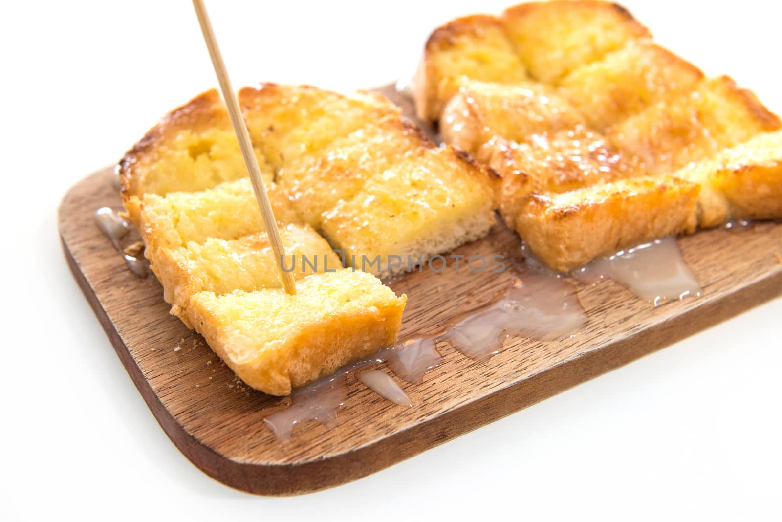 Bread toast and condensed milk on wooden plate by opasstudio