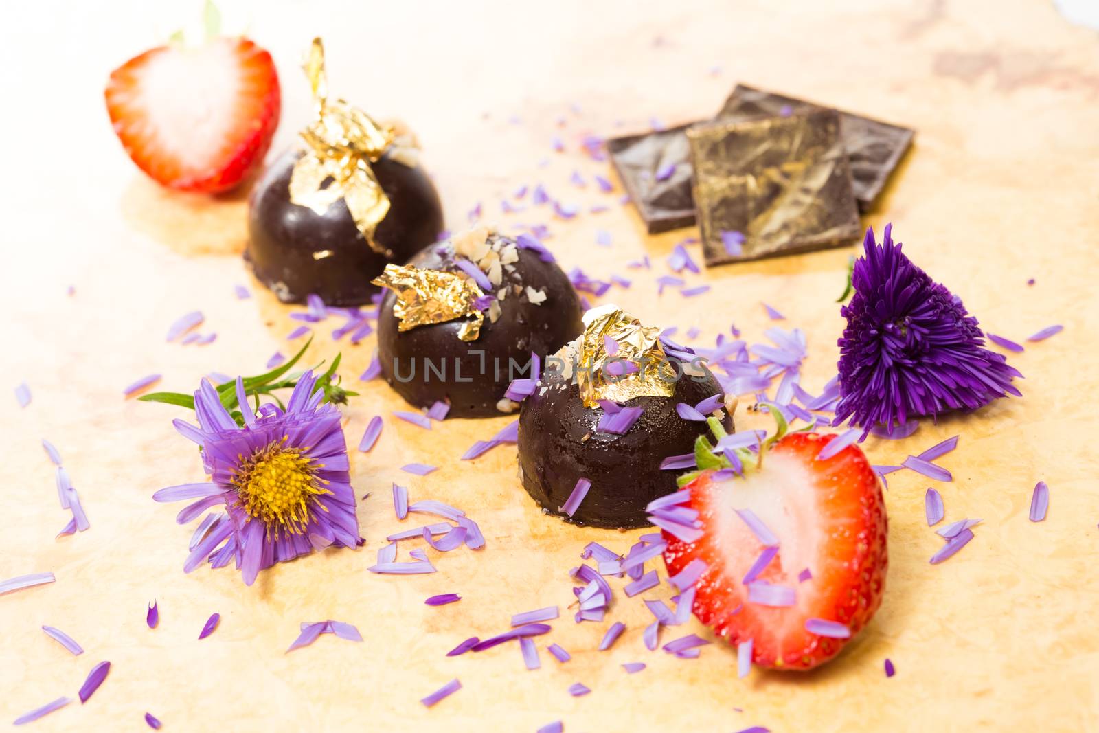 dark chocolate on a wooden table. Decorated with gold leaf. selective Focus