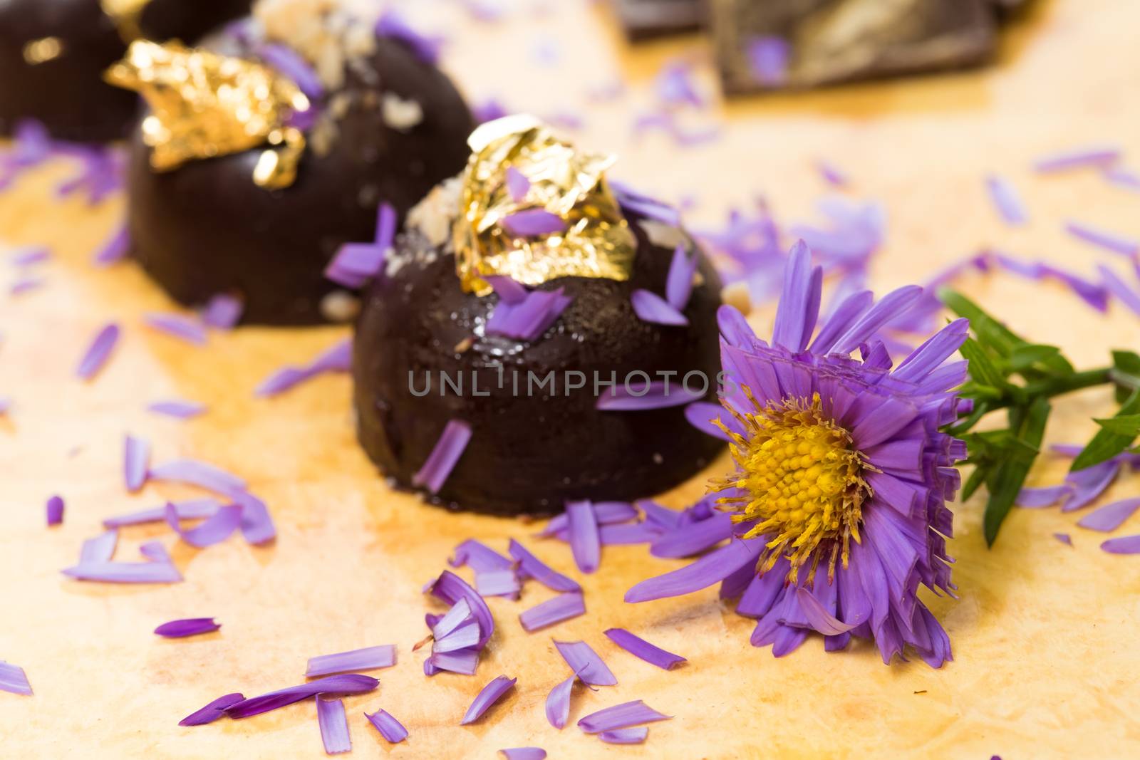 dark chocolate on a wooden table. Decorated with gold leaf. selective Focus