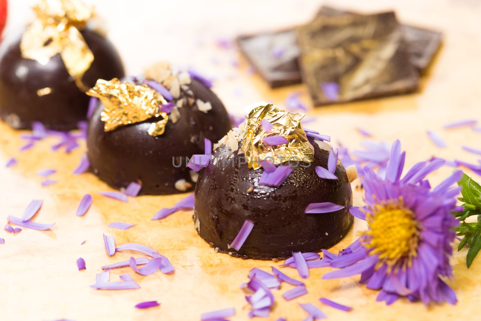 dark chocolate on a wooden table. Decorated with gold leaf. selective Focus