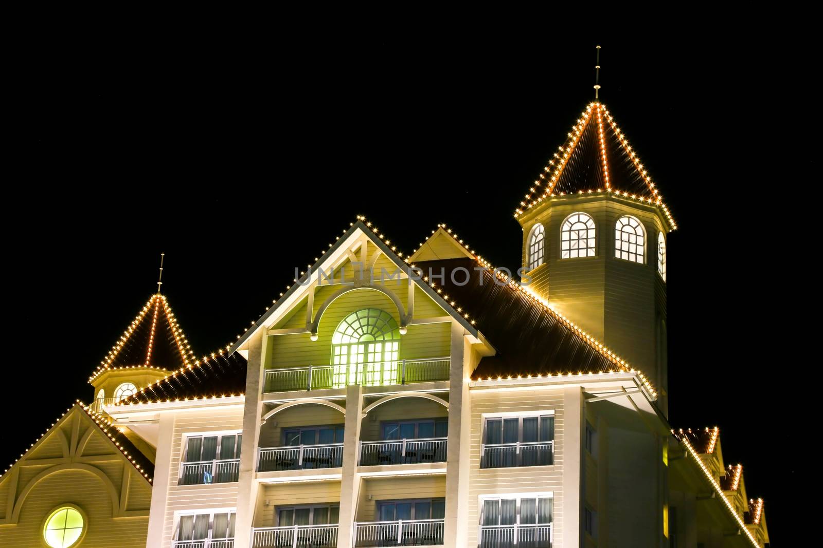 Decorative lights on a building with towers at night