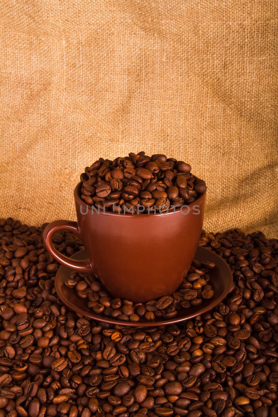 Cup full of coffee beans on the cloth sack