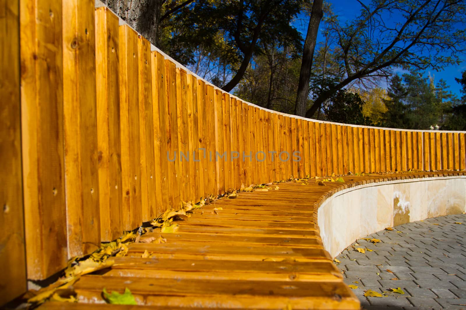 Large wooden bench in autumn park - Stock Image