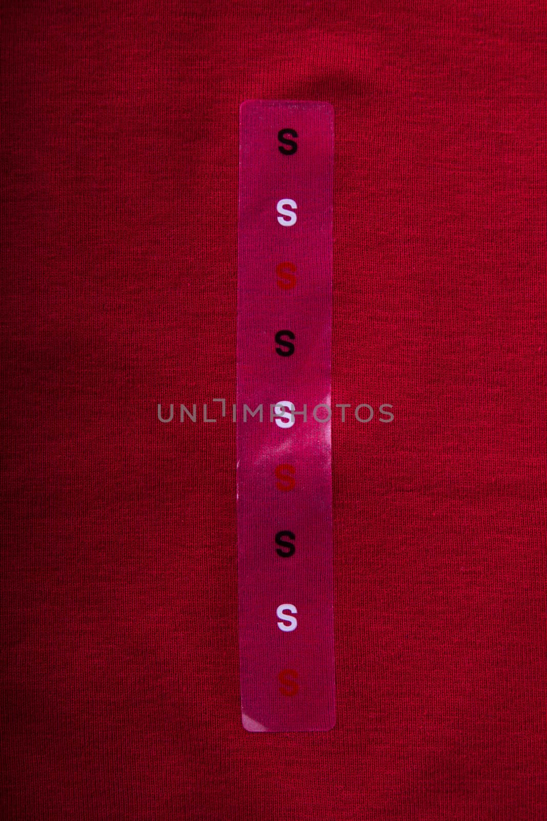 Label size S on red cloth - Stock Image