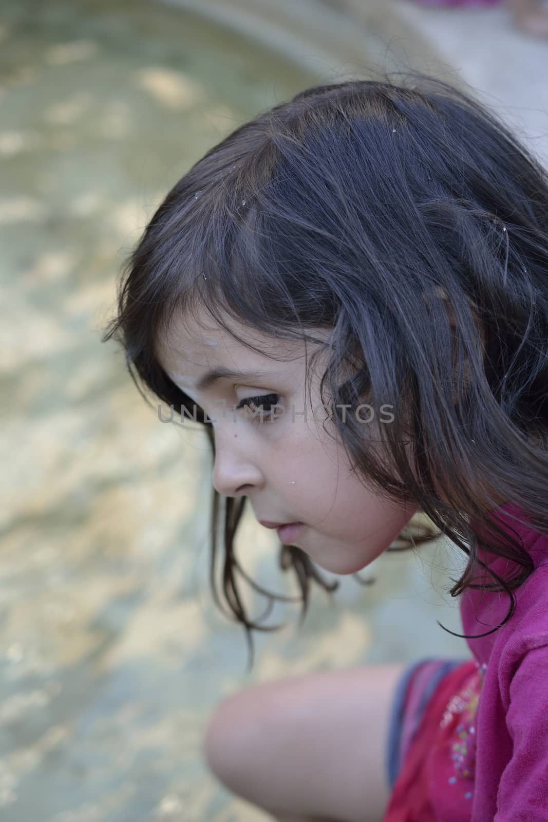 portrait of a girl seated near a fountain by ncuisinier