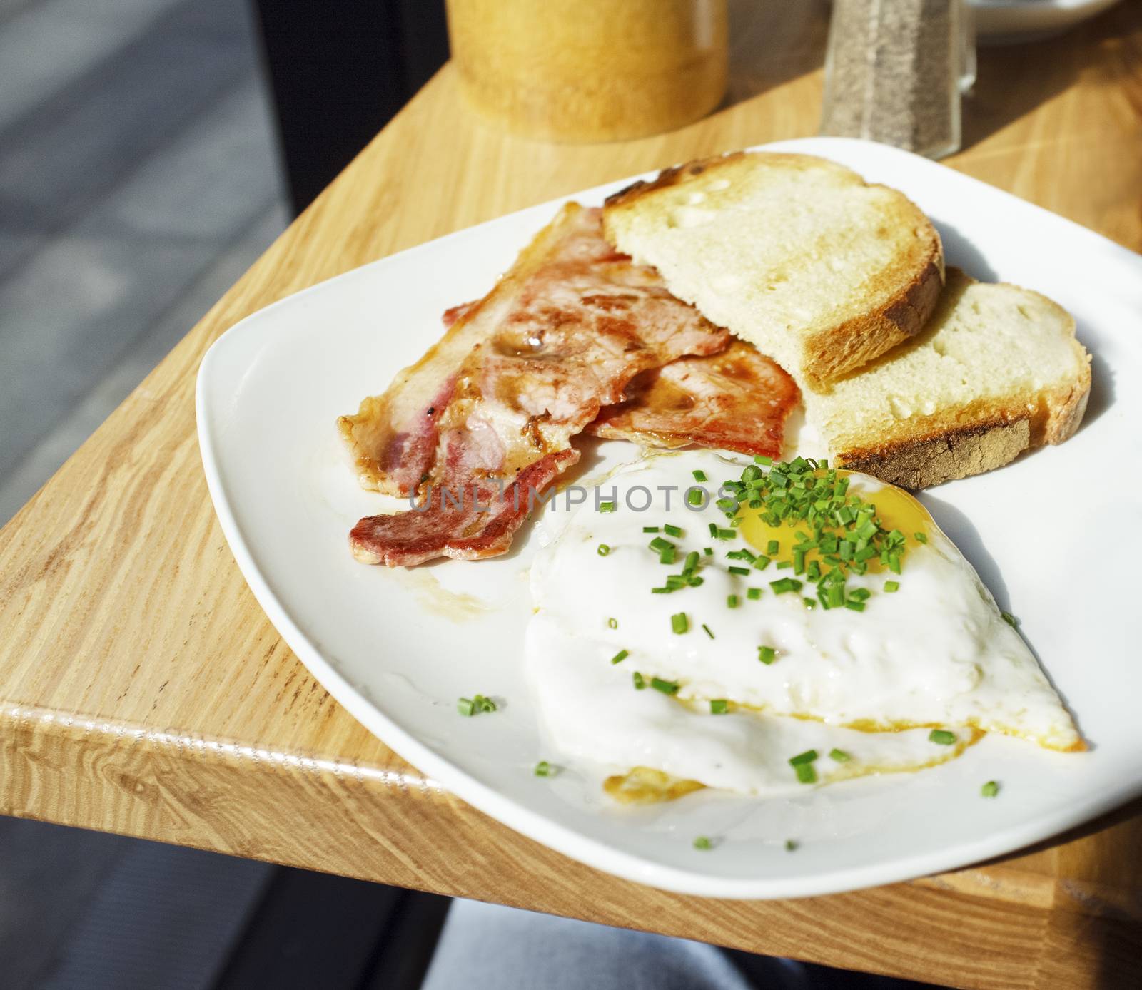 English breakfast consisting of bacon, toast and eggs served on a café in London.