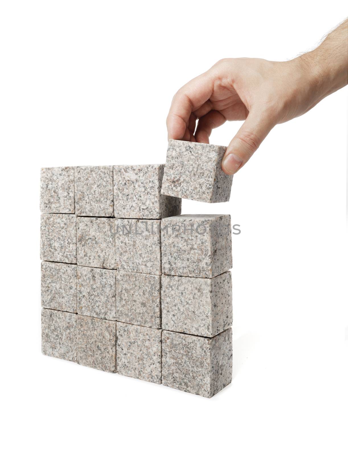 Man making a square shape of blocks made of granite rock.