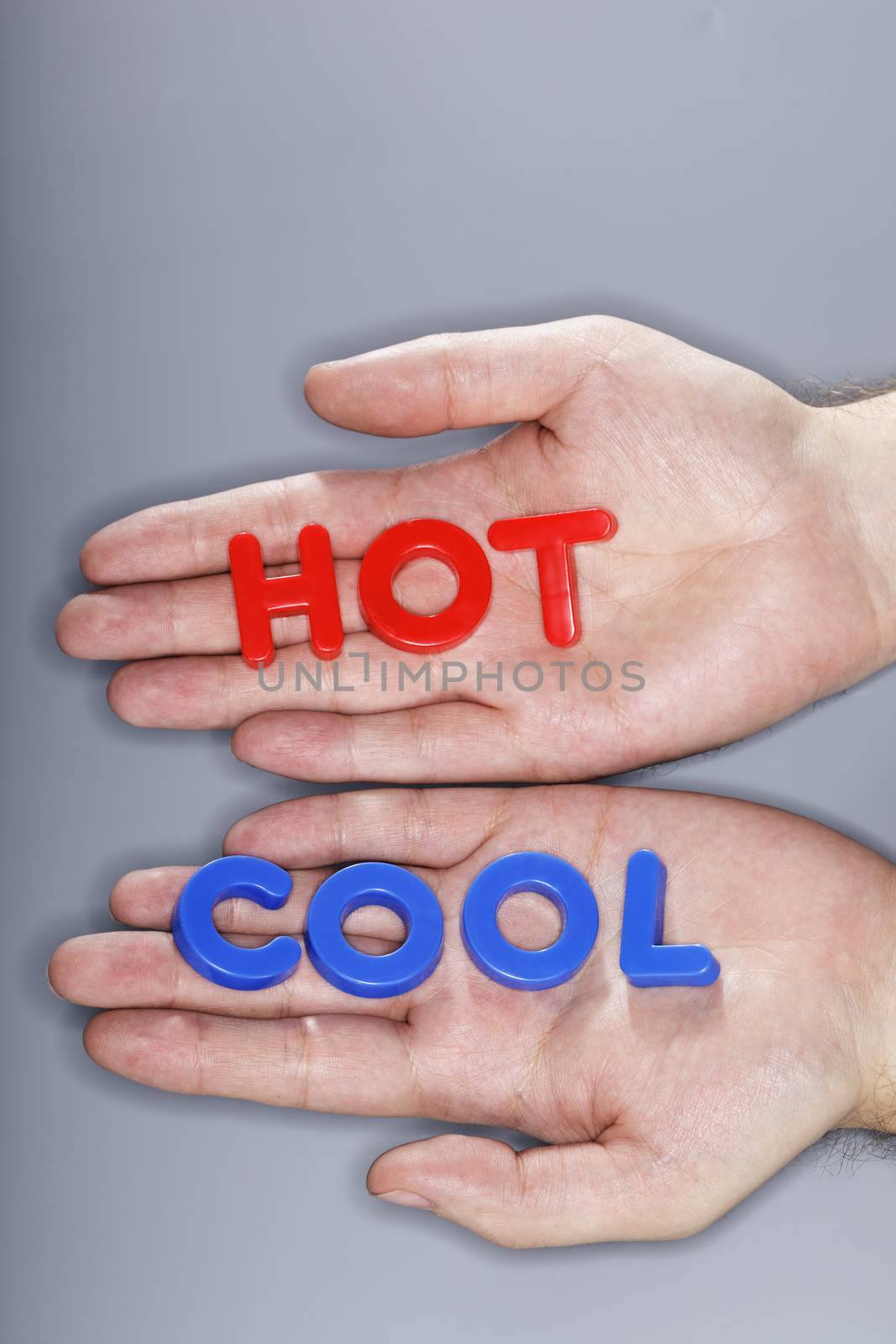 Man holding plastic letters spelling HOT and COOL in his hands.