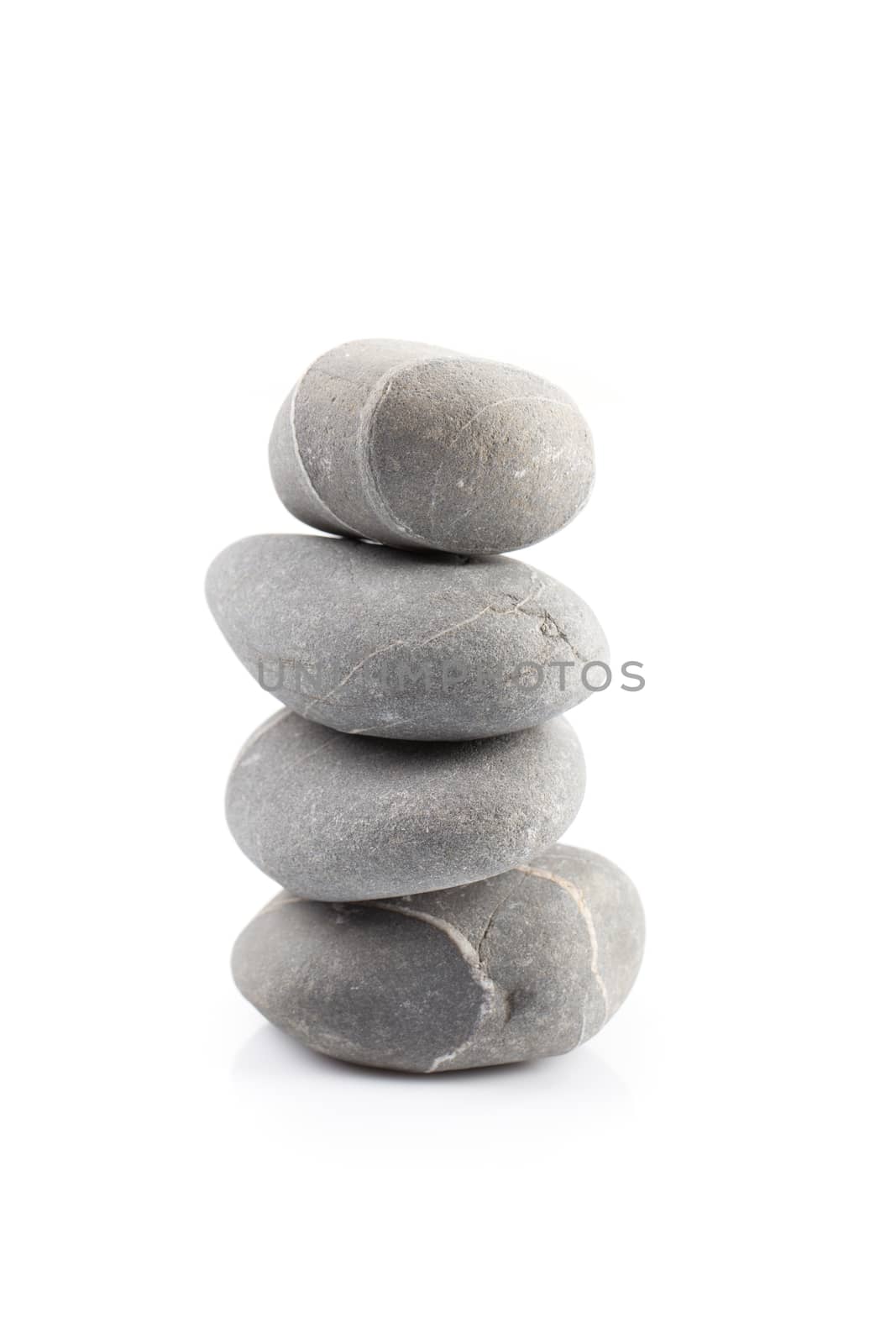 Pyramid of stones over white with reflection shadow