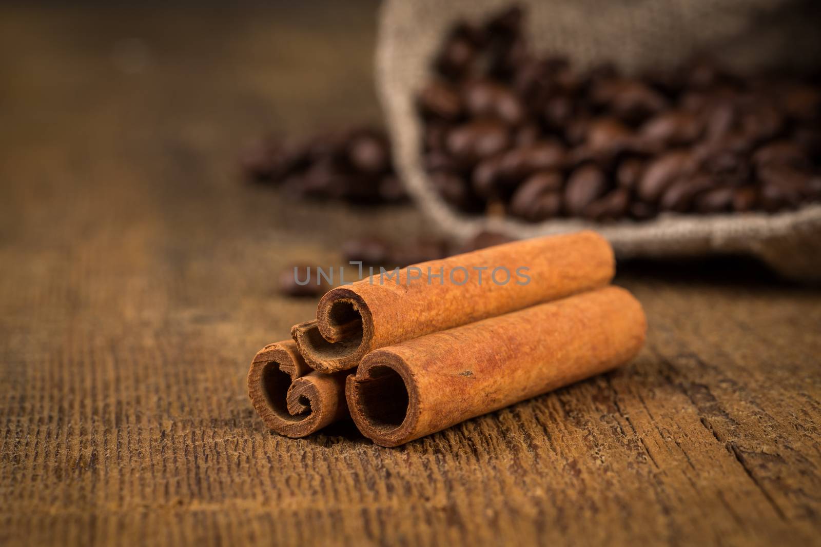 cinnamon sticks and coffee on hessian canvas with wooden background