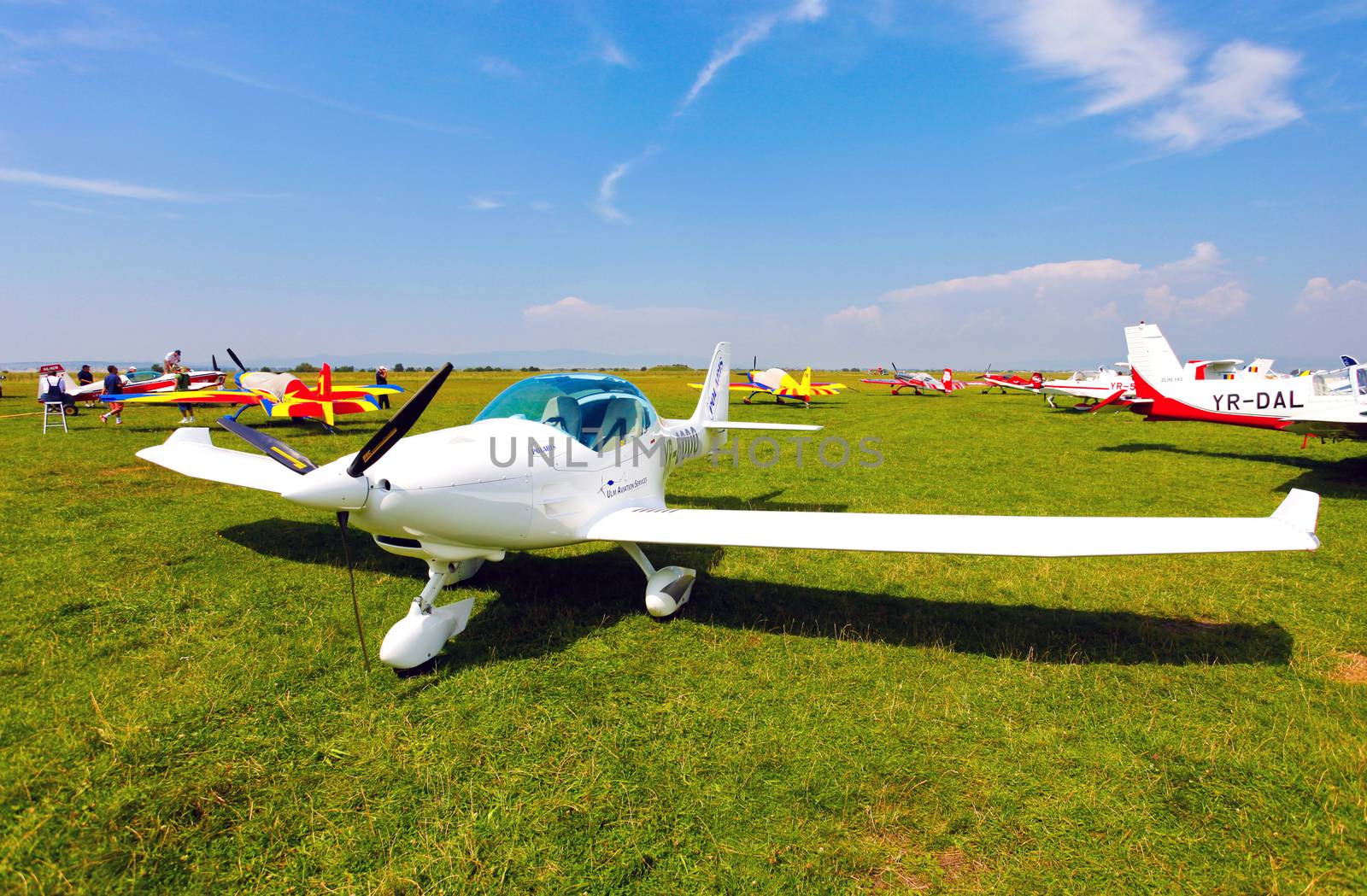 Brasov, Romania - August 12, 2010: White airplane on a green grass field preparing to take off for a flight show