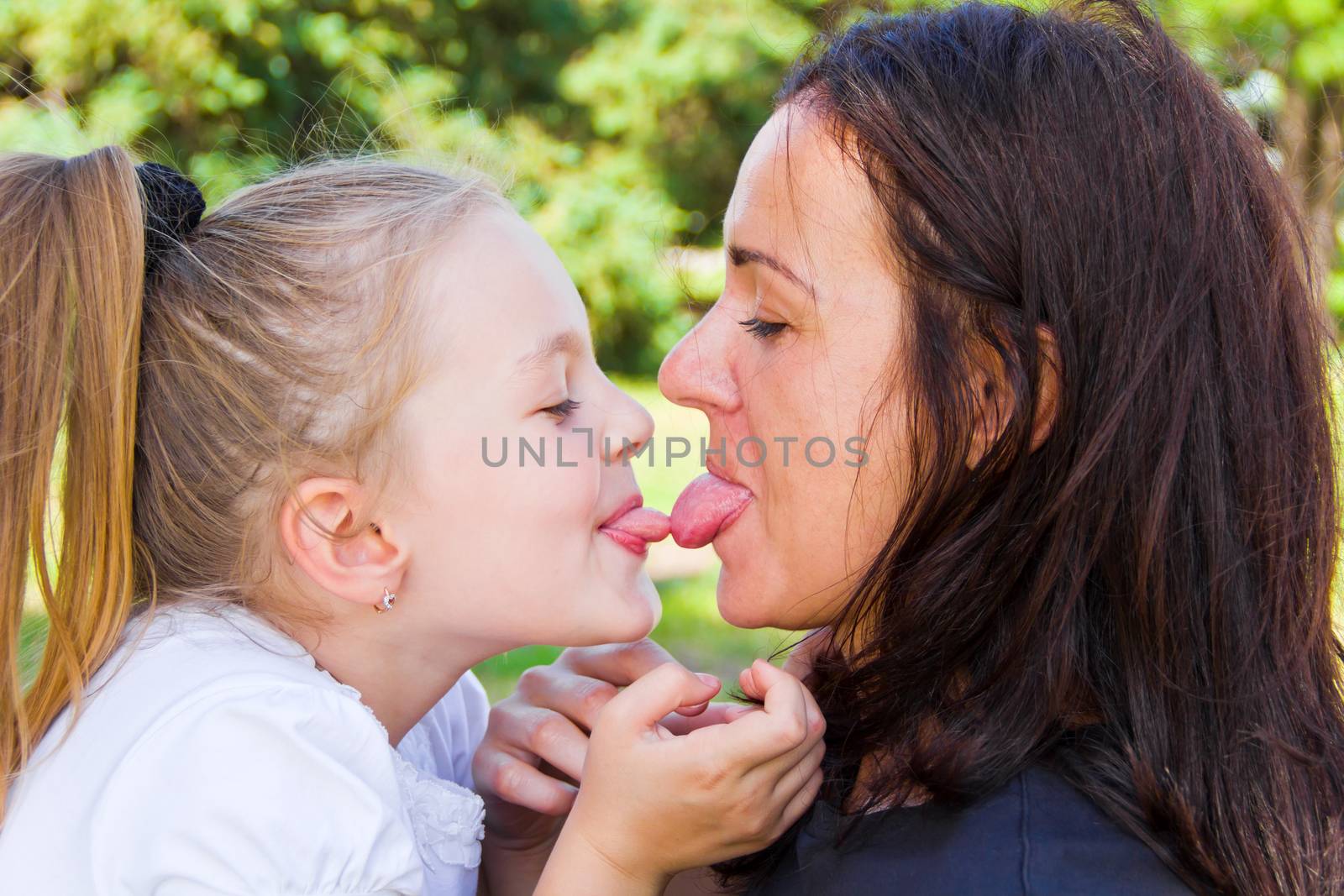 Photo of kissing mother and daughter in summer