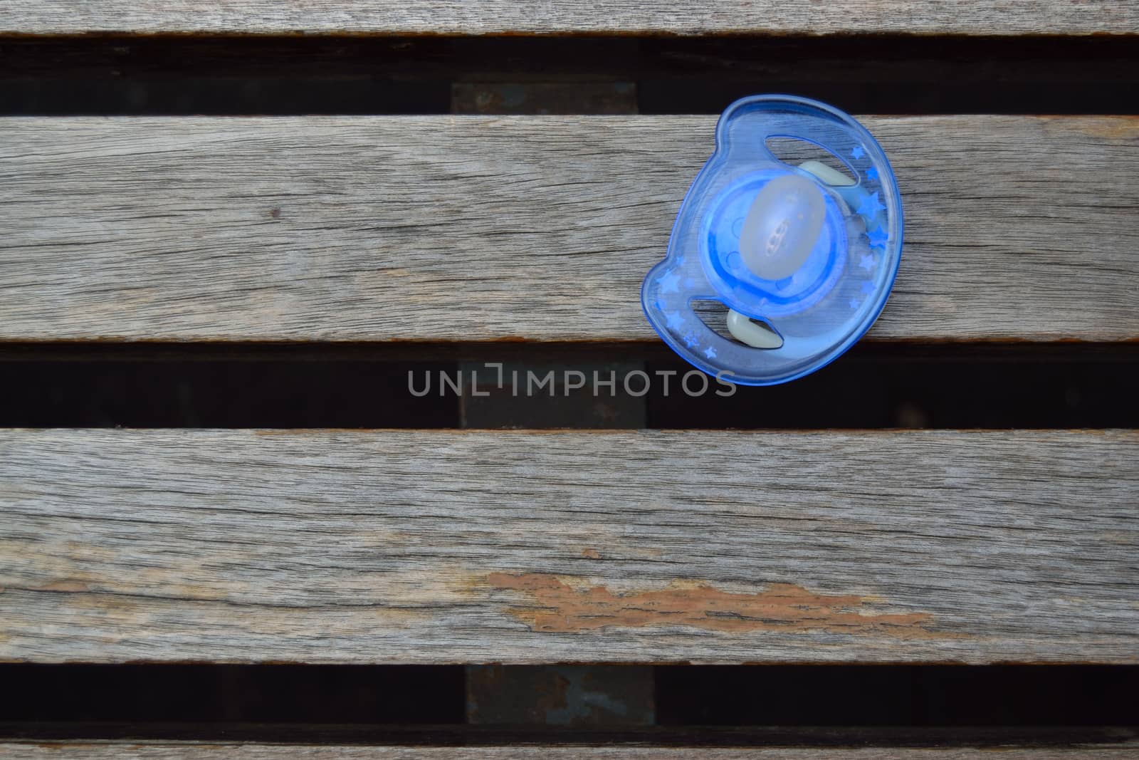 Blue pacifier on a bench by ncuisinier